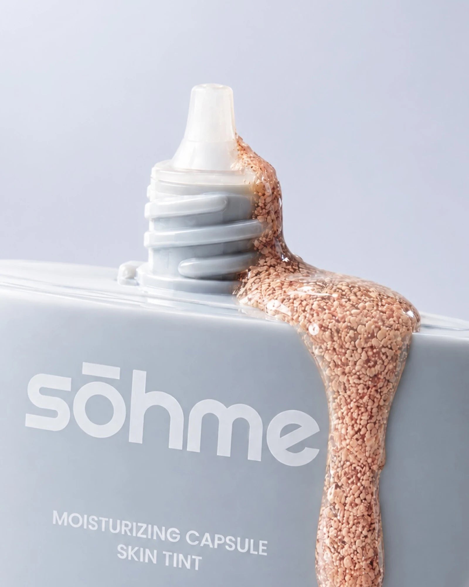 Goutte de skin tint parsemée de capsules teintées